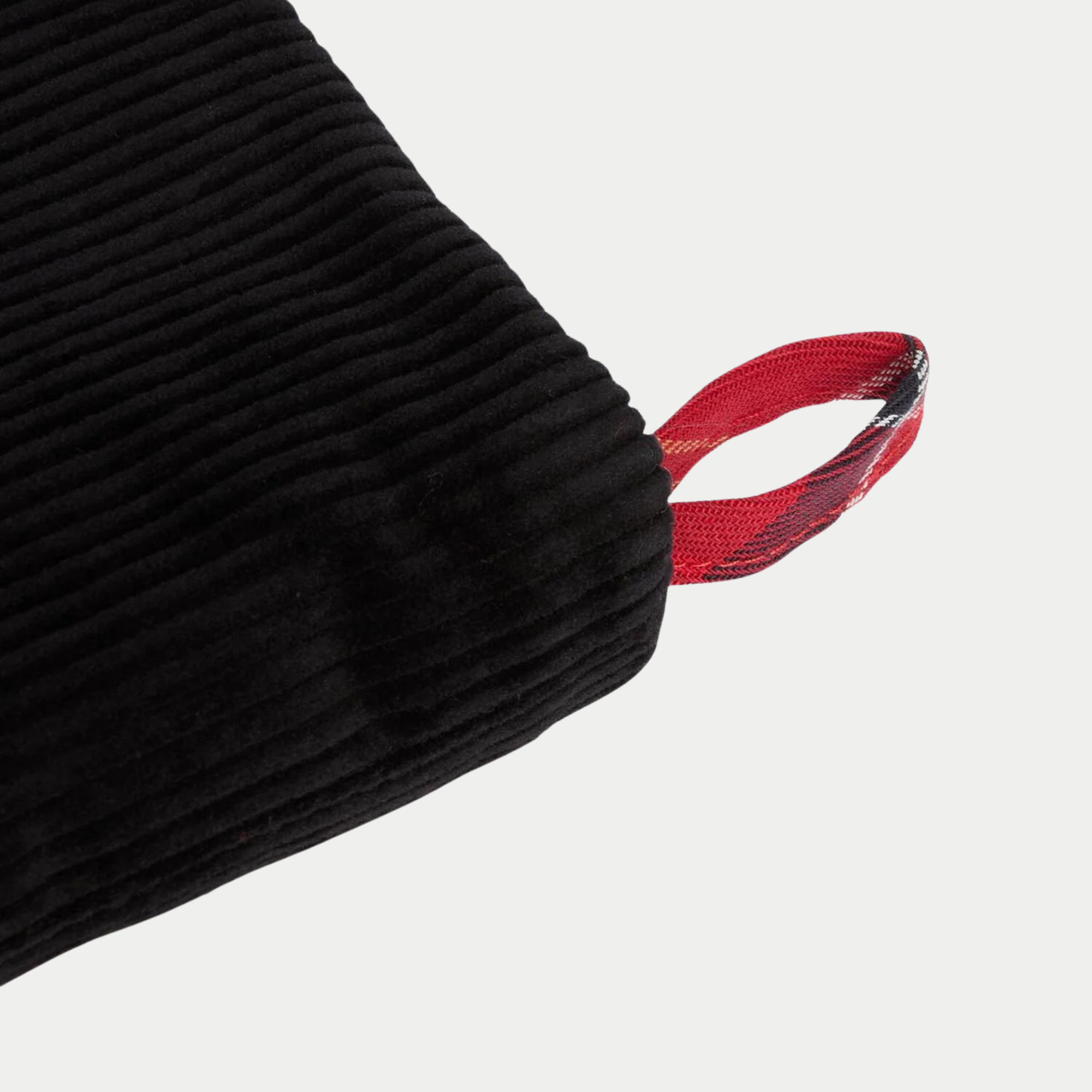 Gros plan sur la boucle d'accroche en sergé tartan rouge cousue au revers de velours côtelé noir de la chaussette