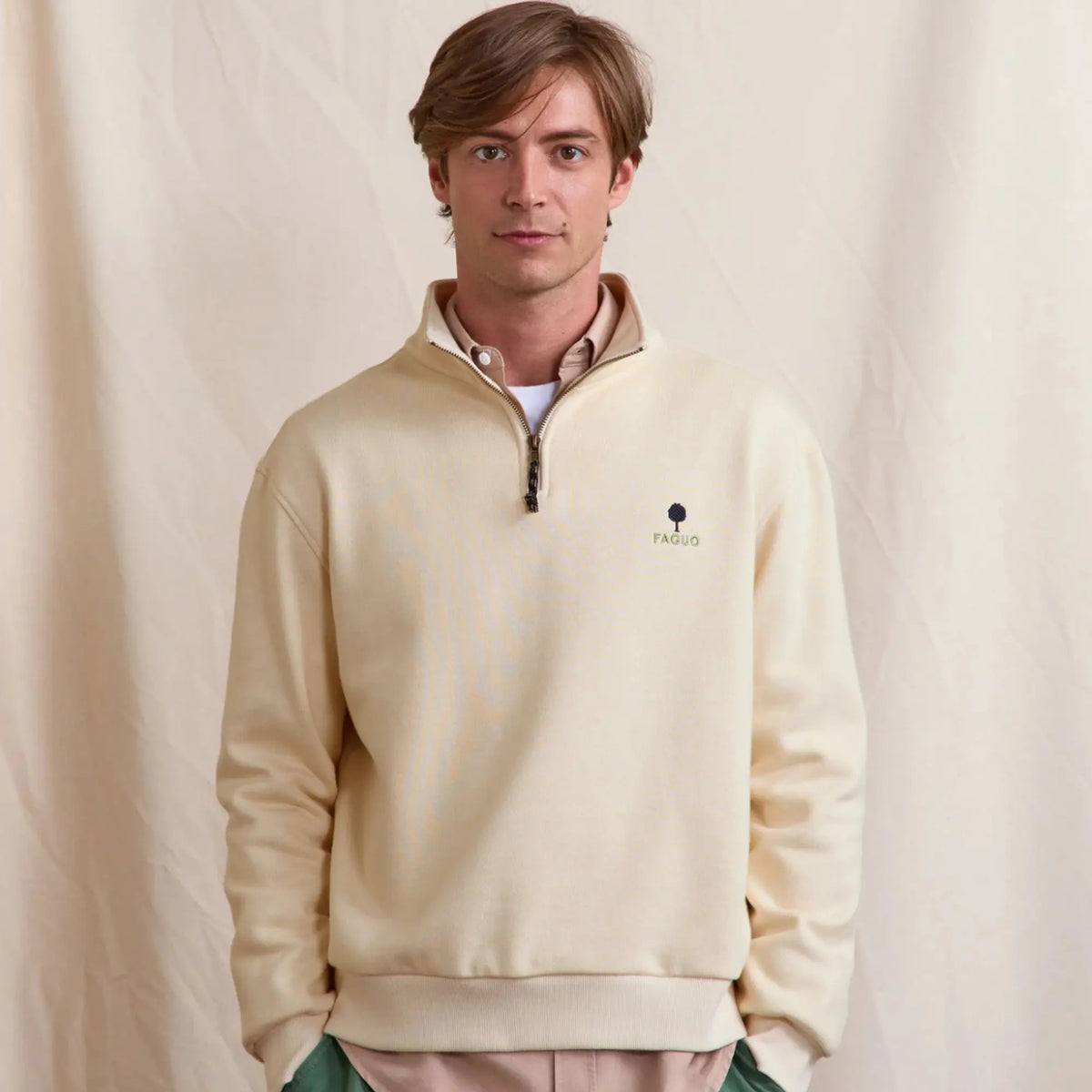 Sweat Amboise écru porté de face, demi-zip ouvert sur une surchemise beige