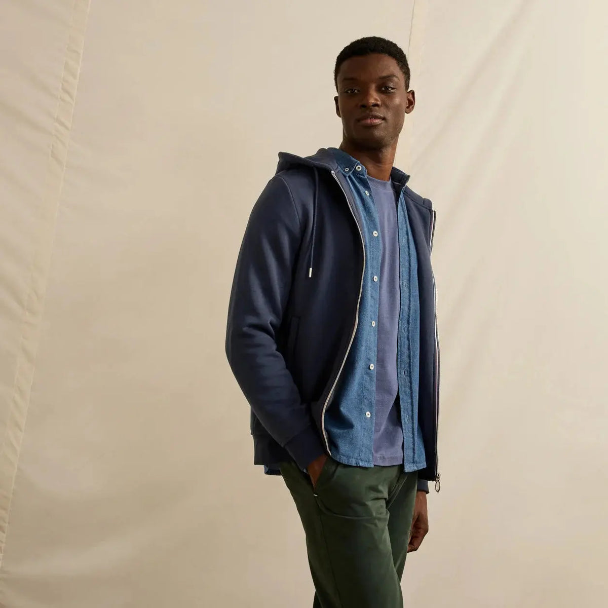 Sweat Mesnil bleu marine porté ouvert debout, capuche dans le dos et pantalon vert