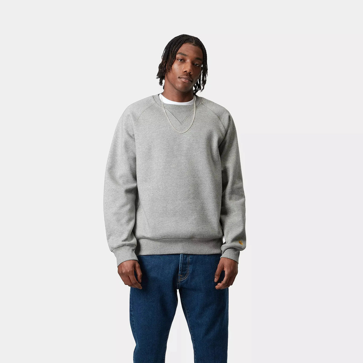 Sweat Chase Carhartt WIP gris chiné porté de face, encolure ronde ras-du-cou et emmanchures raglan, sur un jean