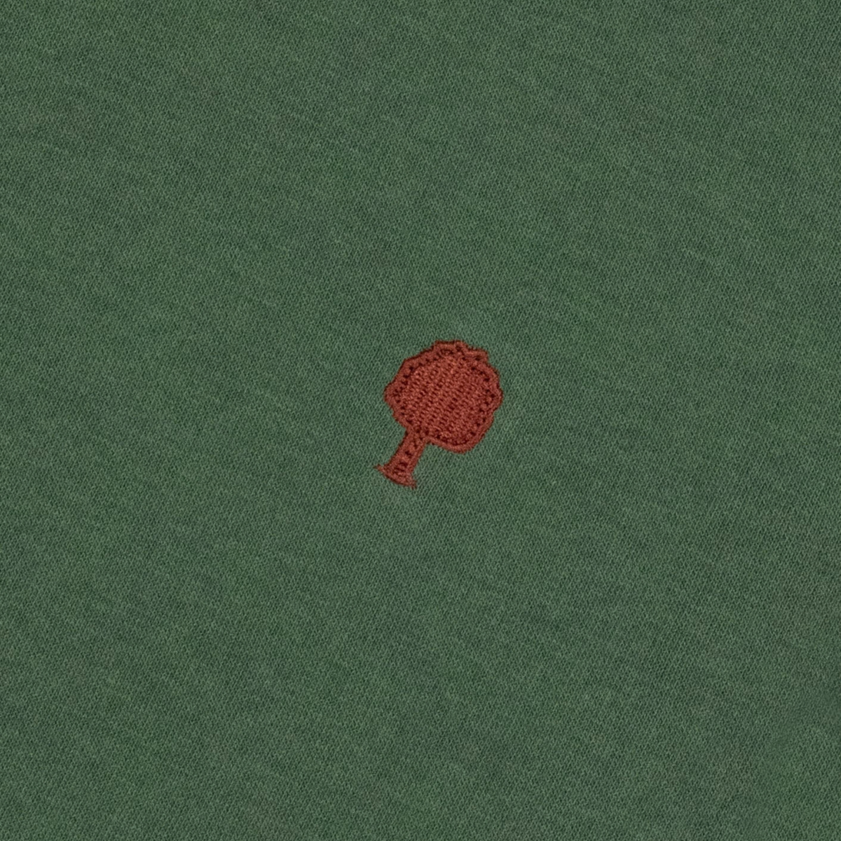 Détail de la broderie arbre rouge brique sur le molleton vert forêt du sweat Donzy Faguo