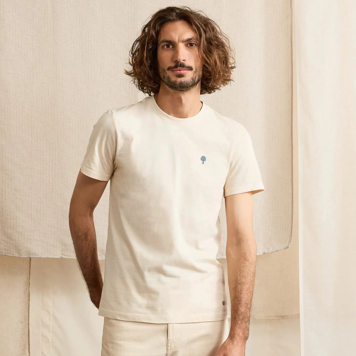 T-shirt Arcy écru uni porté de face avec un pantalon écru, manches courtes