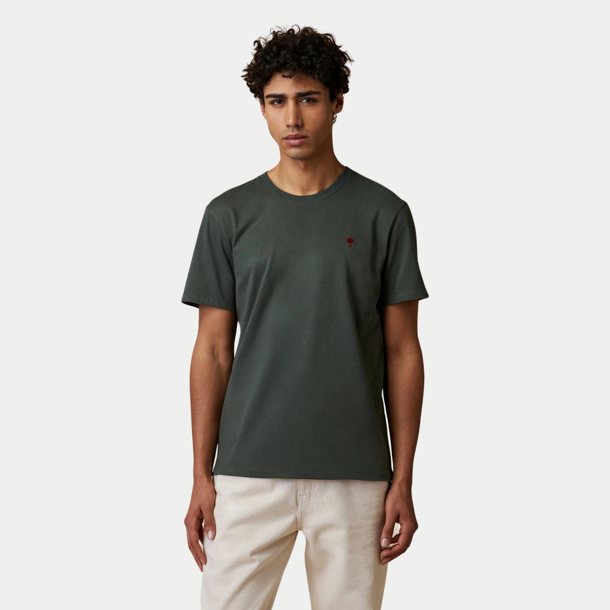 T-shirt Arcy Faguo vert foncé porté de face avec un pantalon écru, coupe droite