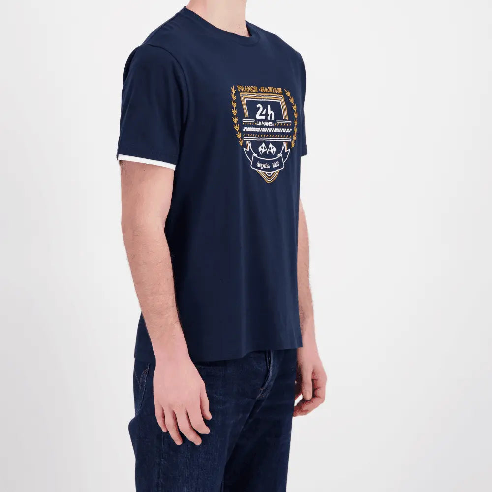 T-shirt bleu marine vu de trois quarts, broderie aux lauriers dorés et bords de manches blancs