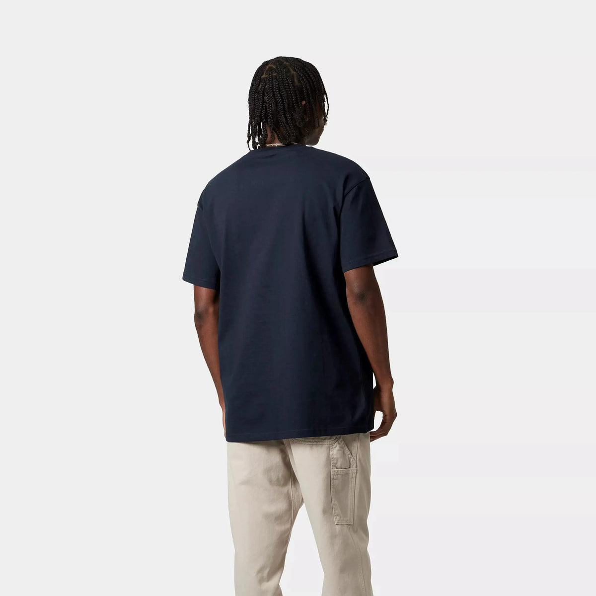 Homme de dos portant le T-shirt Chase Dark Navy et un pantalon Carhartt WIP écru