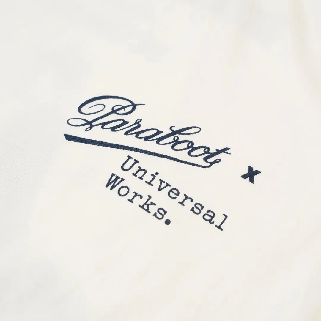 Gros plan du logo Paraboot x Universal Works imprimé en bleu marine sur coton blanc cassé