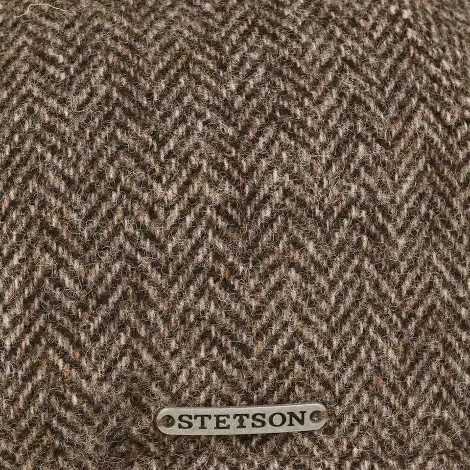 Gros plan du tissage chevrons brun et beige et de la plaquette métal gravée