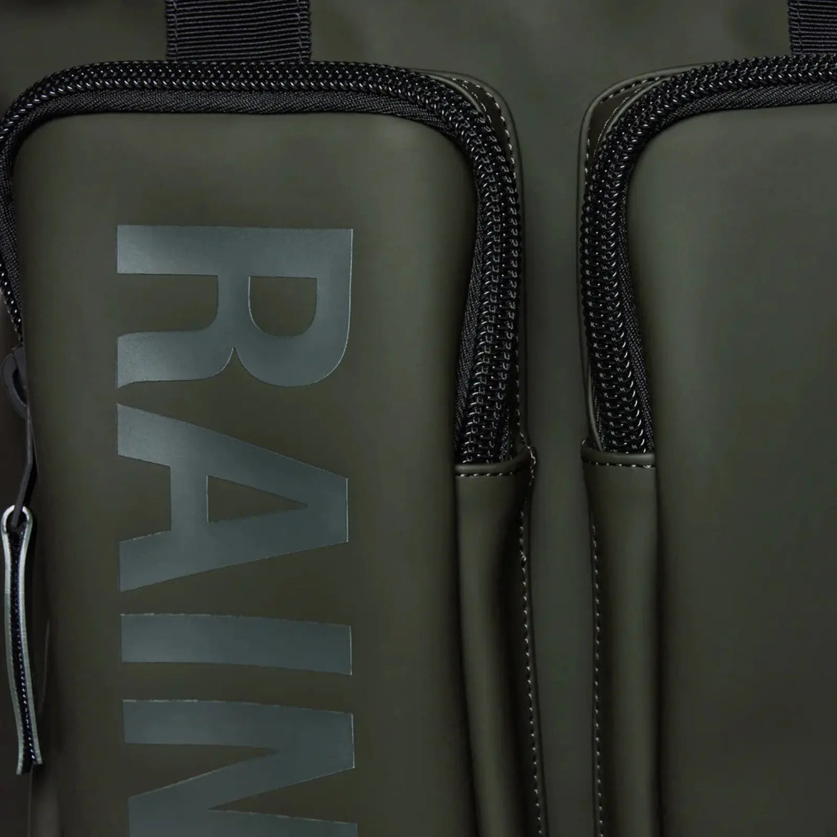 Macro sur la matière vert kaki du Texel Tote Backpack, lettrage embossé et zips noirs