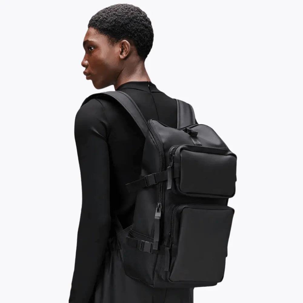 Trail Cargo Backpack noir porté, silhouette haute et boucles latérales noires