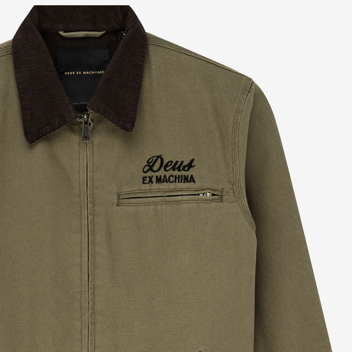 Détail du col en velours côtelé marron, de la poche poitrine zippée et du logo Deus brodé, veste Address Workwear olive
