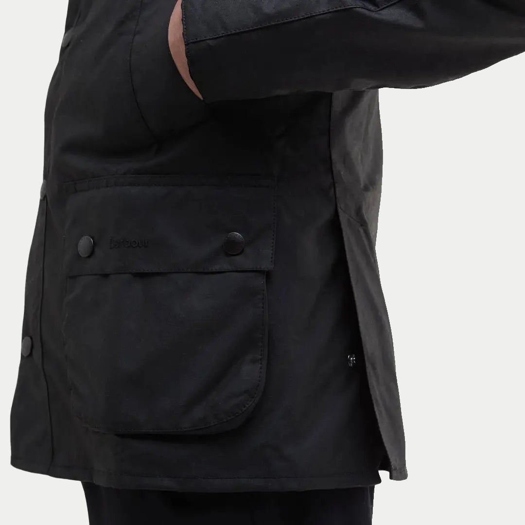 Poche à rabat plaquée de la veste Ashby noire vue de trois quarts, pressions et Barbour brodé