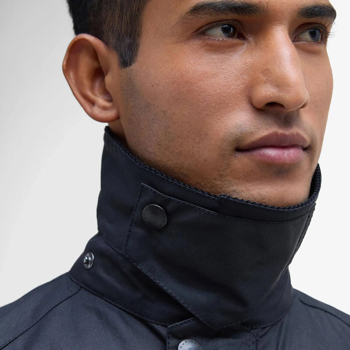Col montant de la veste Ashby marine relevé et fermé par pression, protection du cou