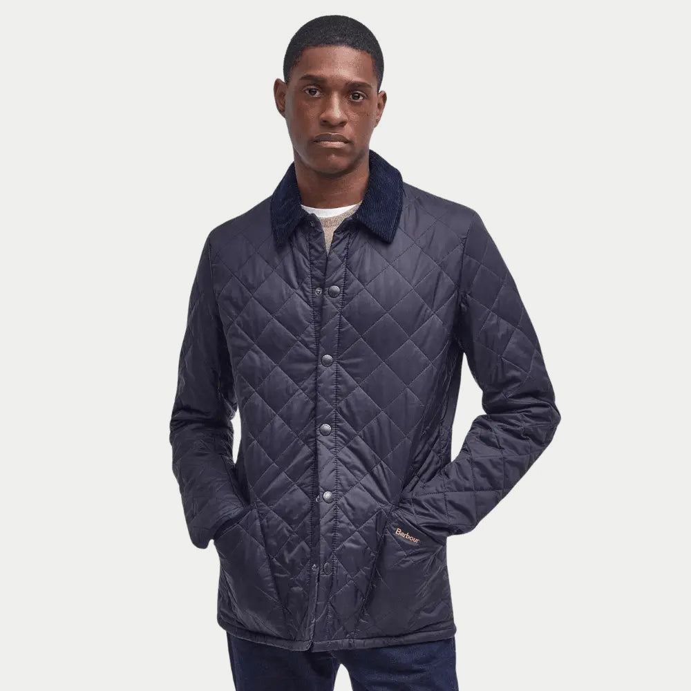Veste matelassée Liddesdale bleu marine Barbour portée ouverte sur une maille écrue, mains dans les poches passepoilées