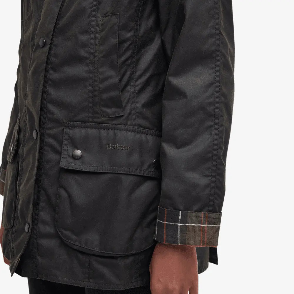 Détail de la poche basse à rabat de la Veste cirée Barbour Beadnell olive et de son revers de poignet en tartan