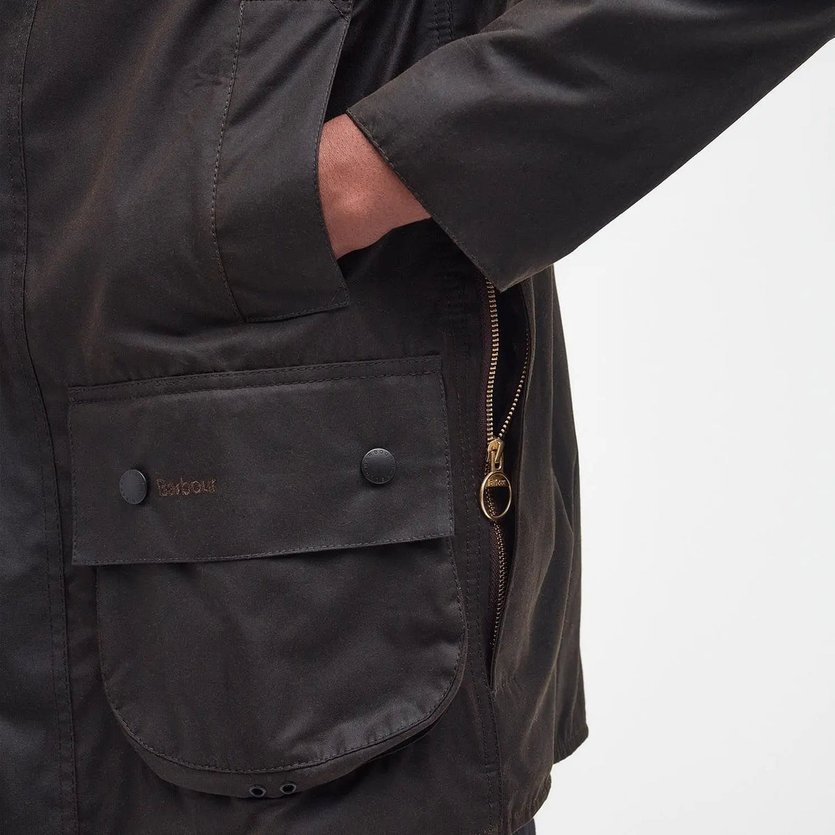 Poches superposées et zip laiton ouvert de la veste cirée Beaufort olive, vue de côté