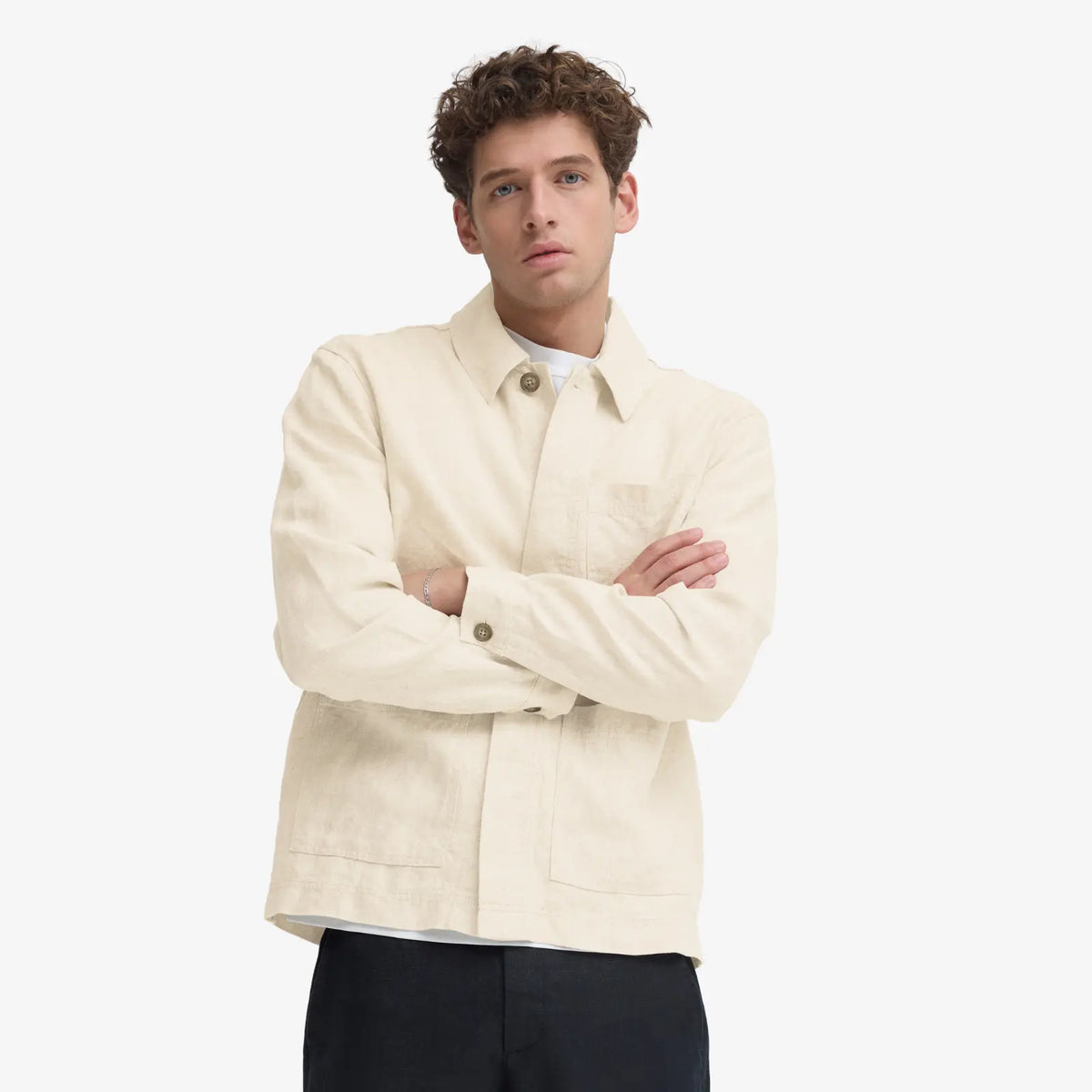 Veste en lin beige naturel portée ouverte sur un t-shirt blanc et un pantalon noir, coupe droite à la hanche