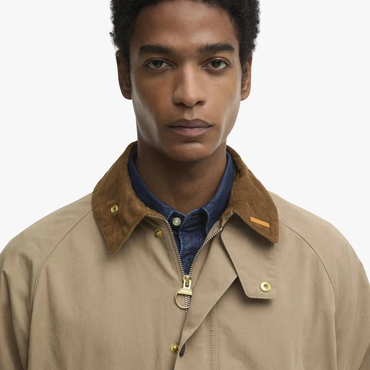 Détail du col en velours côtelé brun de la Bedale beige, zip laiton à anneau et étiquette cuir Barbour.