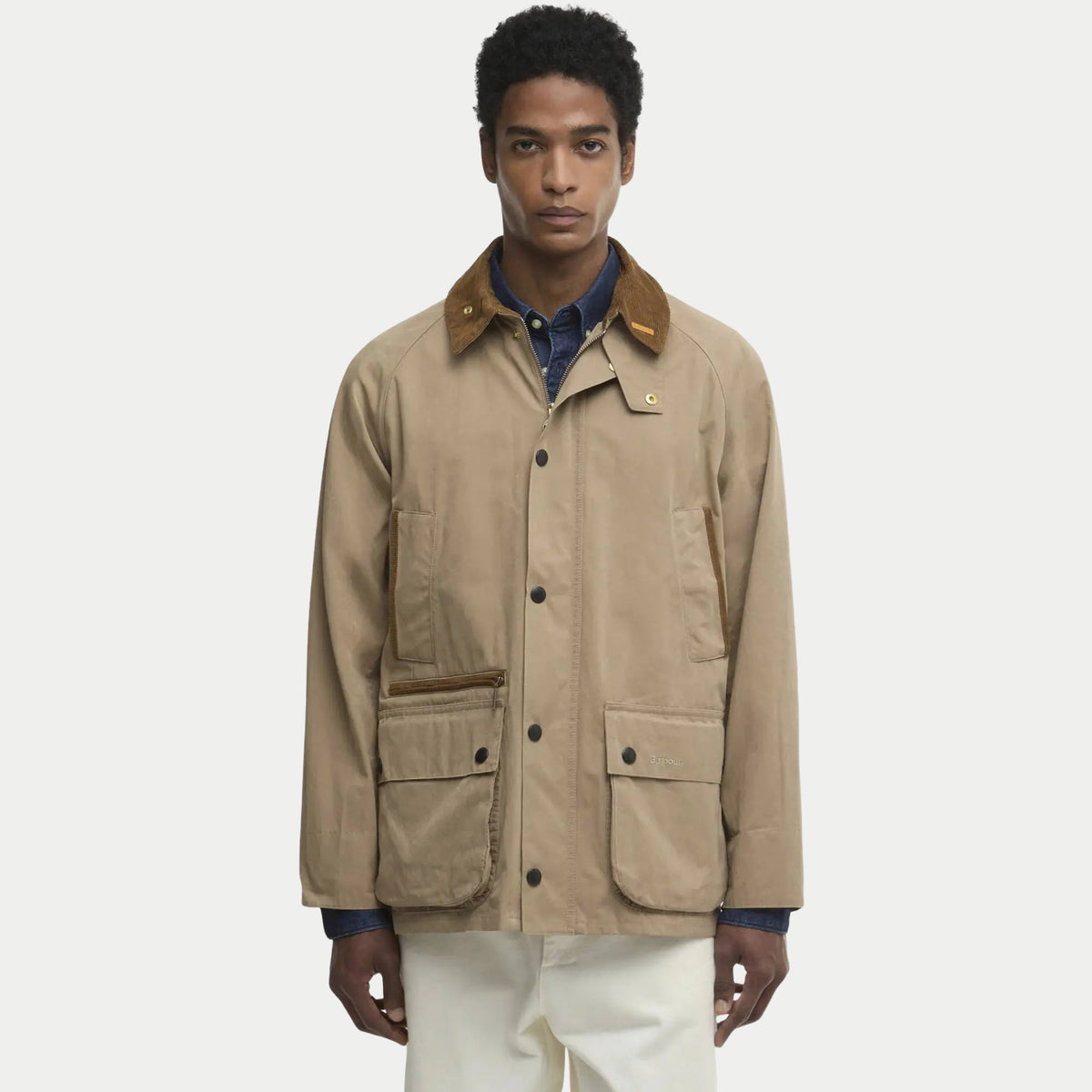Bedale Casual beige portée ouverte sur une chemise en jean, pressions dorées et col en velours brun.