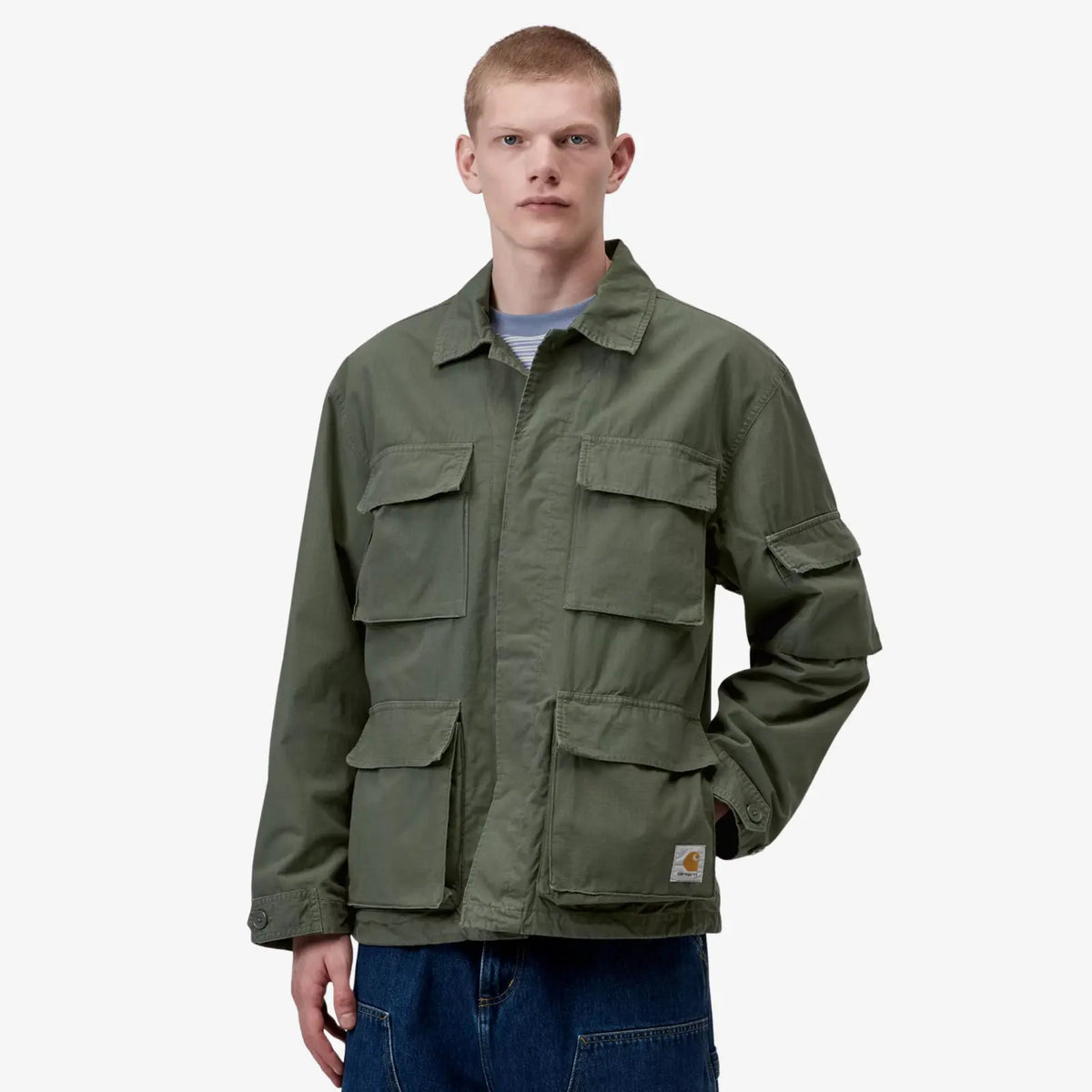 Veste Manderson kaki portée de face, col chemise ouvert, poches basses à soufflet et étiquette logo en bas
