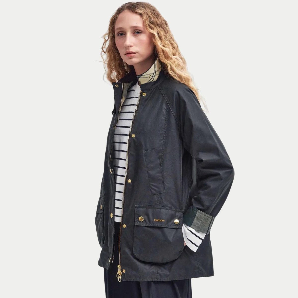 Veste cirée Barbour Modern Beadnell Sage portée ouverte sur une marinière, vue de trois quarts