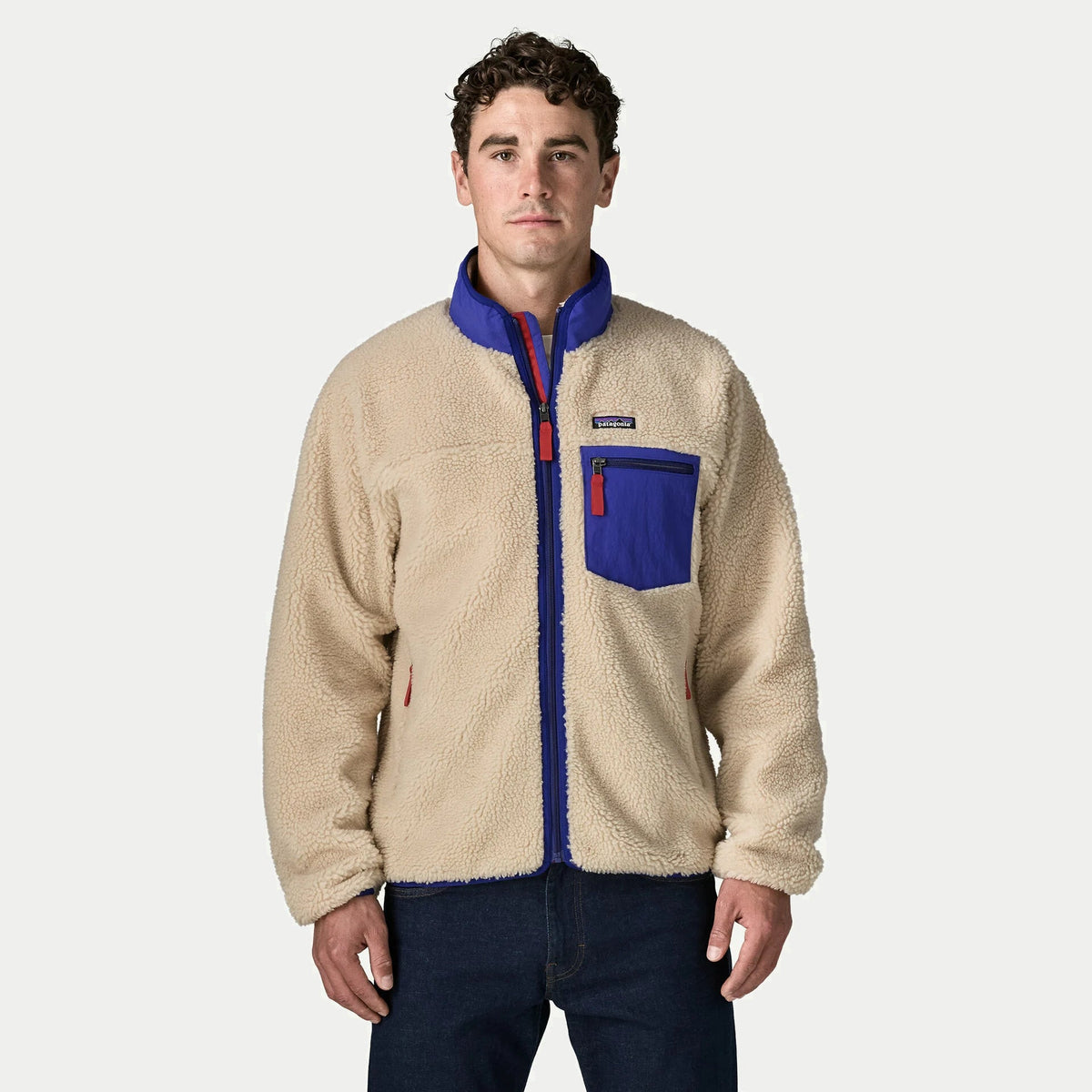 Veste polaire Retro-X Patagonia sherpa écru portée de face, col montant cobalt relevé, poche poitrine zippée