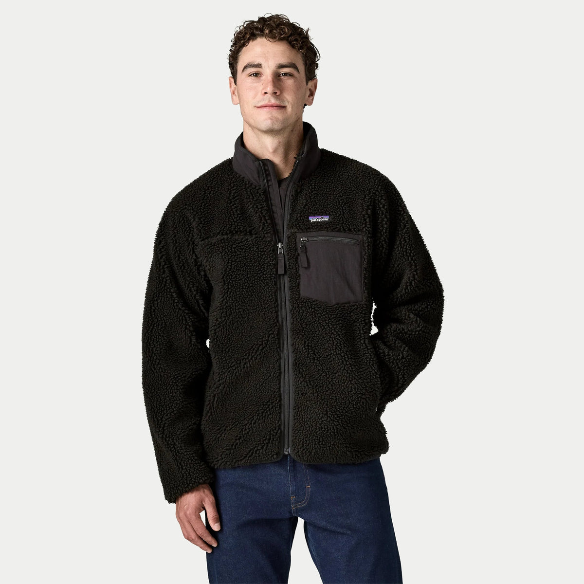Veste Retro-X noire Patagonia portée de face, zip pleine longueur et poche poitrine nylon anthracite zippée