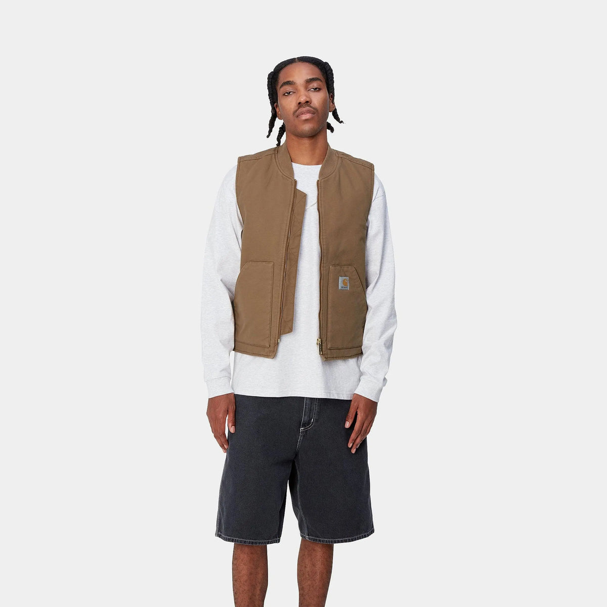 Veste sans manches brun caramel portée ouverte sur un sweat gris clair, vue de face en pied