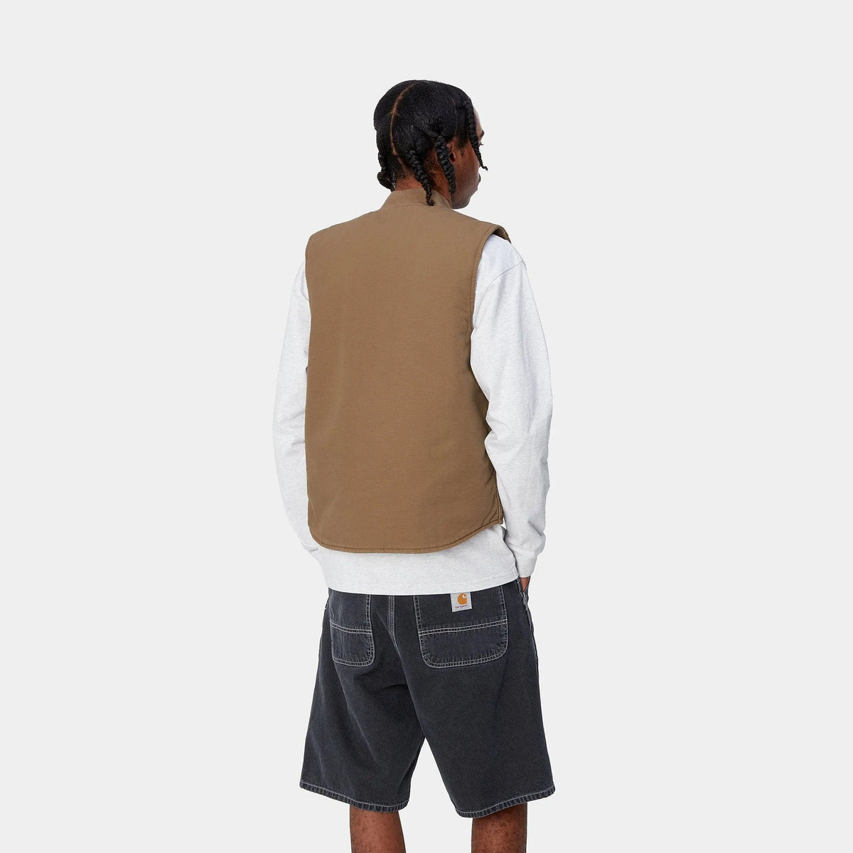 Vue de dos portée : veste sans manches brun caramel, dos uni et emmanchures larges sur un sweat clair