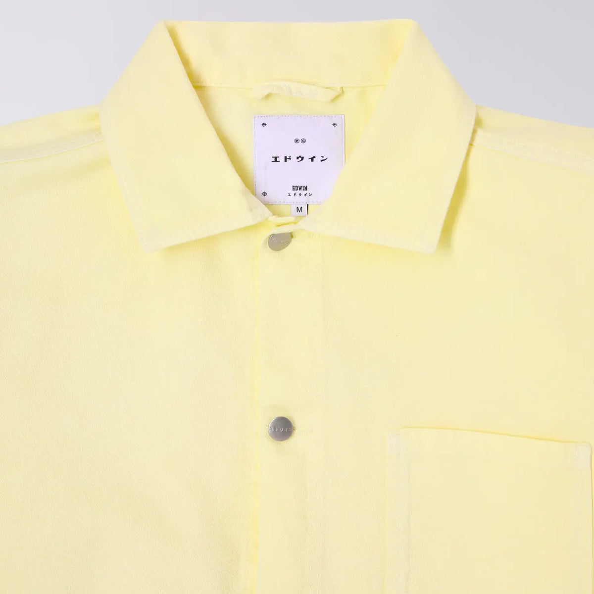 Col de la veste Trembley Whisper White, étiquette de marque japonaise et boutons argentés gravés
