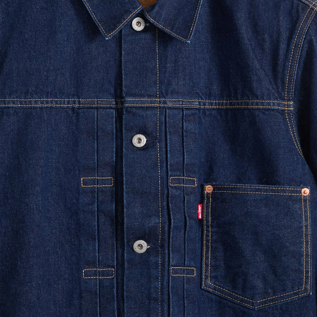 Détail poitrine de la veste Levi's Type I Trucker : boutons gravés Levi Strauss & Co, plis et rivets cuivre