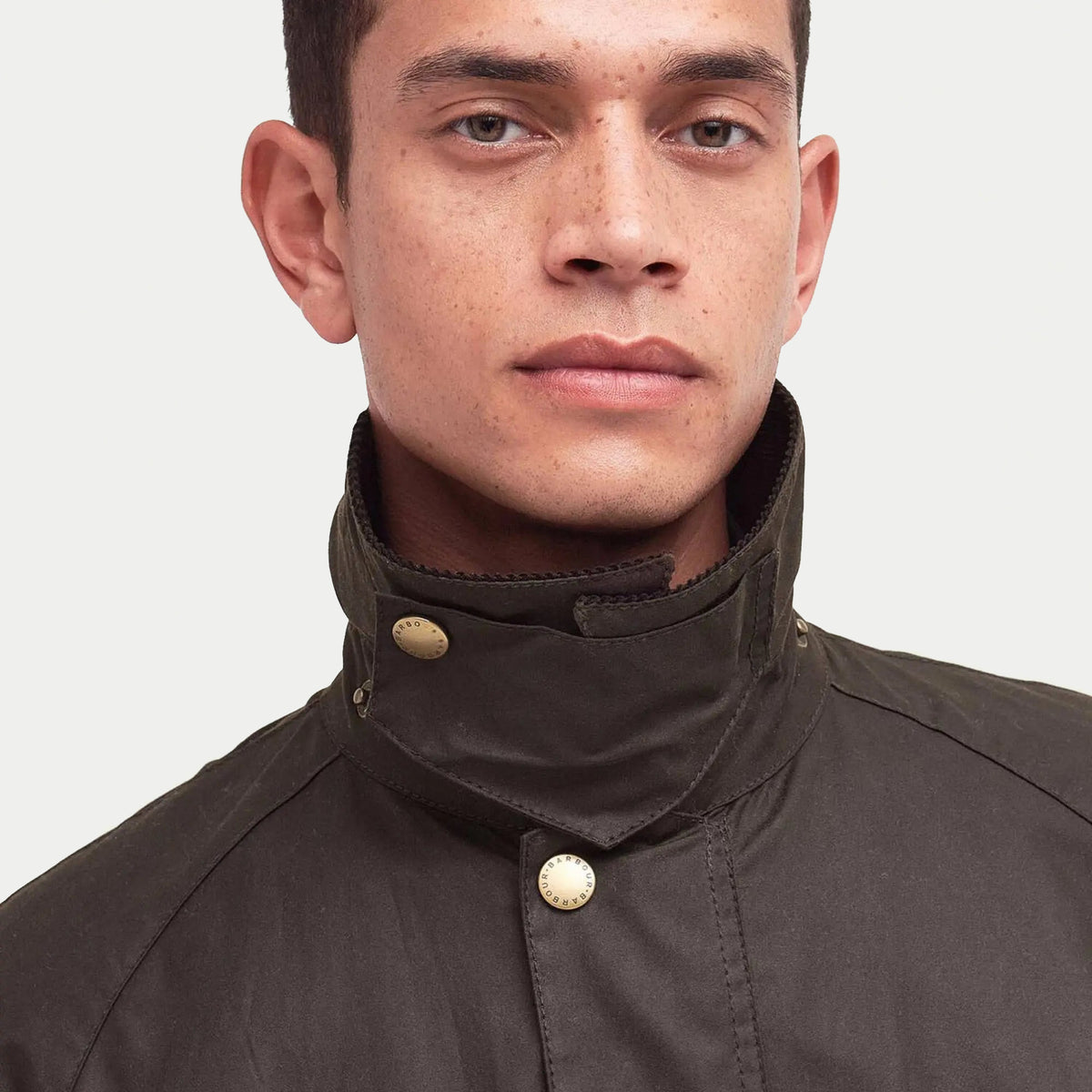 Col relevé de la veste Ashby olive fermé par deux pressions laiton, protection du cou