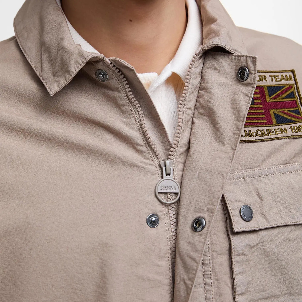 Zip de la Workers Casual beige sous patte à pressions, tirette gravée Barbour International
