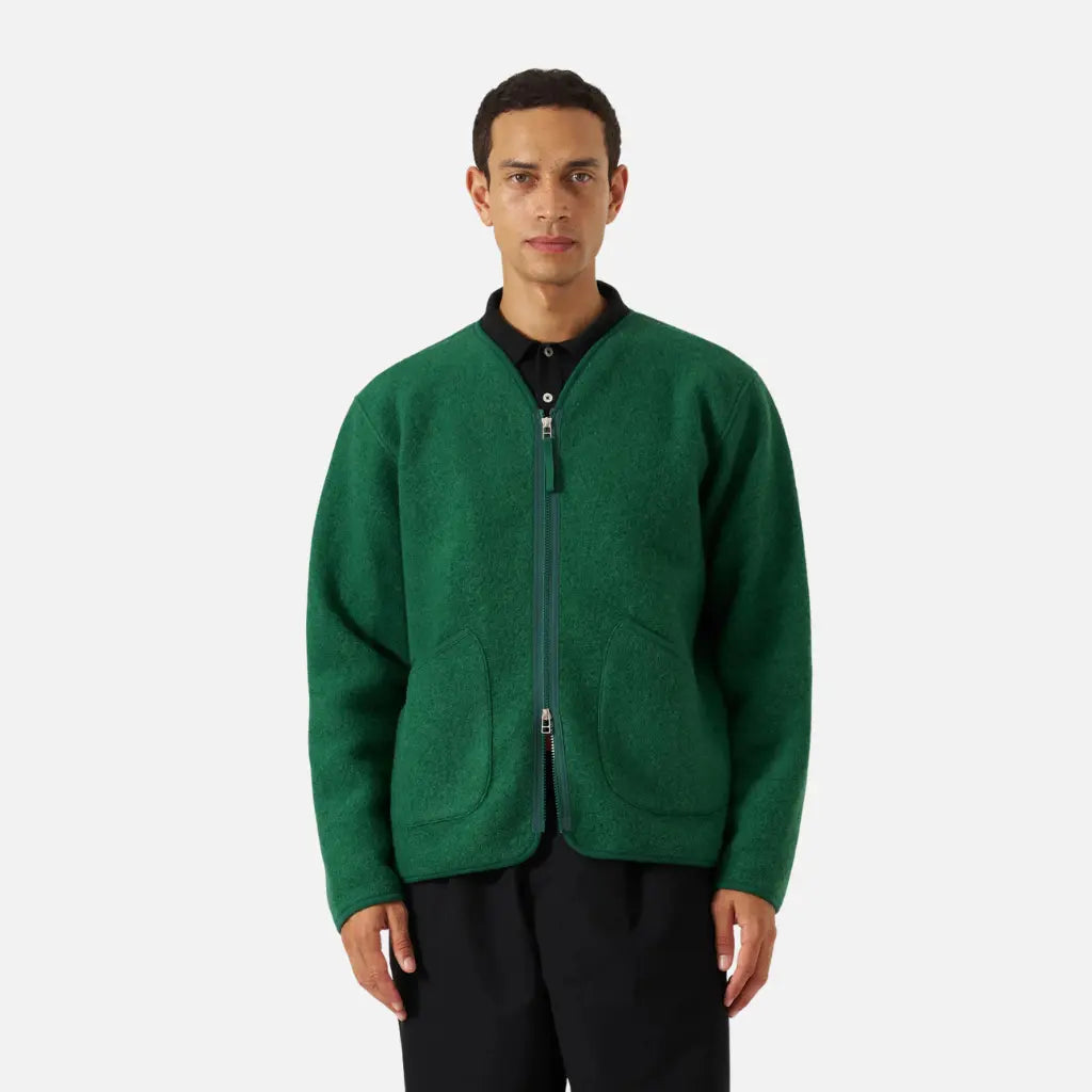 Veste Zip Liner verte portée ouverte sur un polo noir, tombé souple de la laine