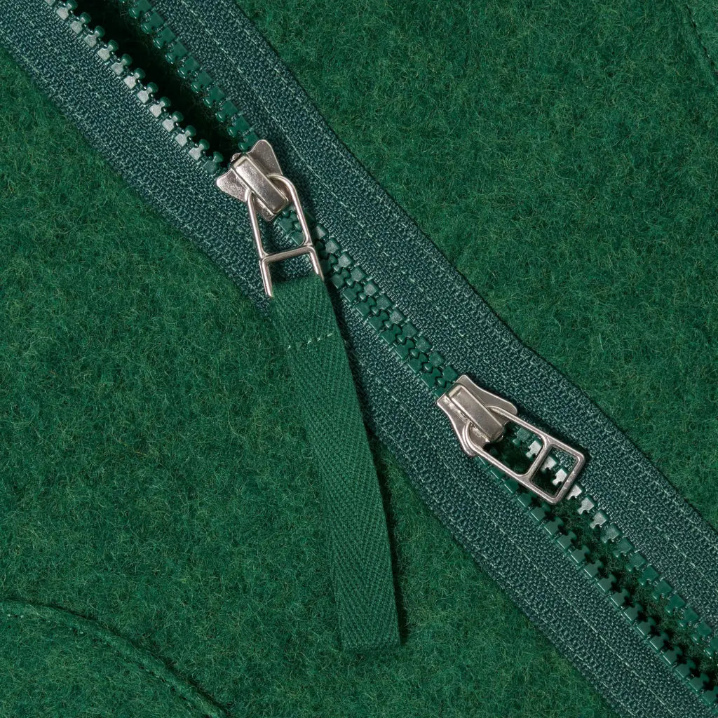 Détail du zip vert à double curseur de la Zip Liner et de sa patte de protection