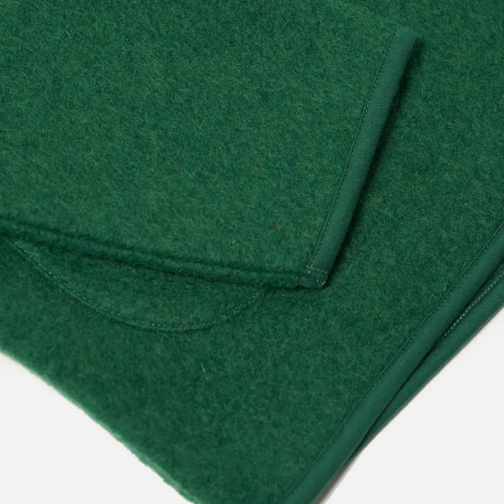 Bas de la veste Zip Liner, bord gansé et angle d'une poche plaquée arrondie en laine verte