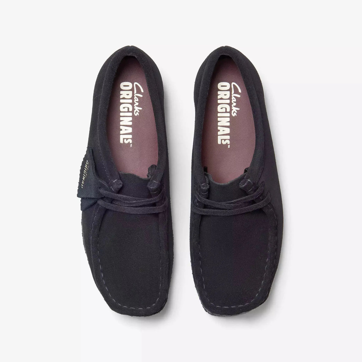 Wallabee noires vues de dessus, lacets noirs et premières de propreté rose