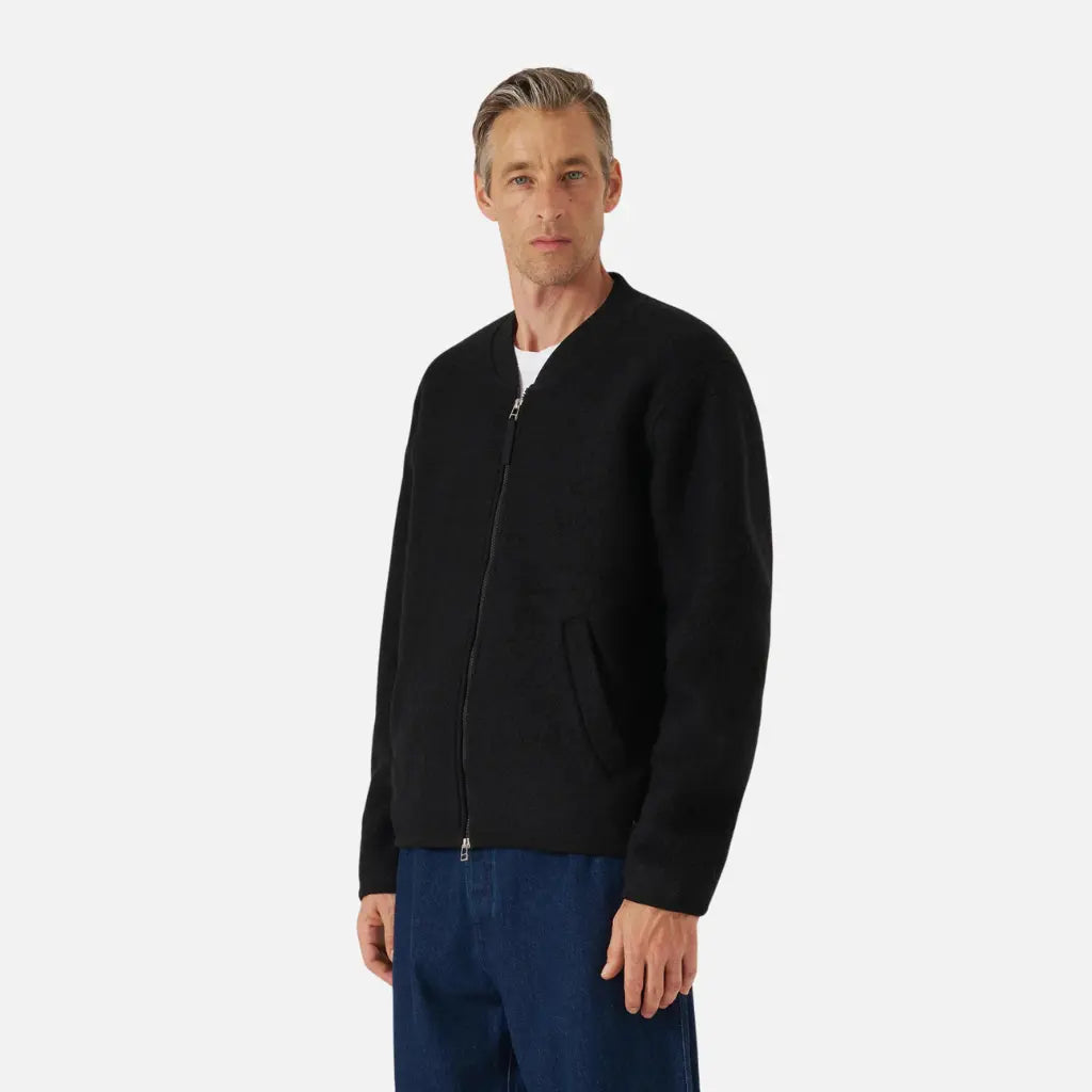 Zip Bomber noir porté fermé de trois quarts sur un jean brut, tombé court